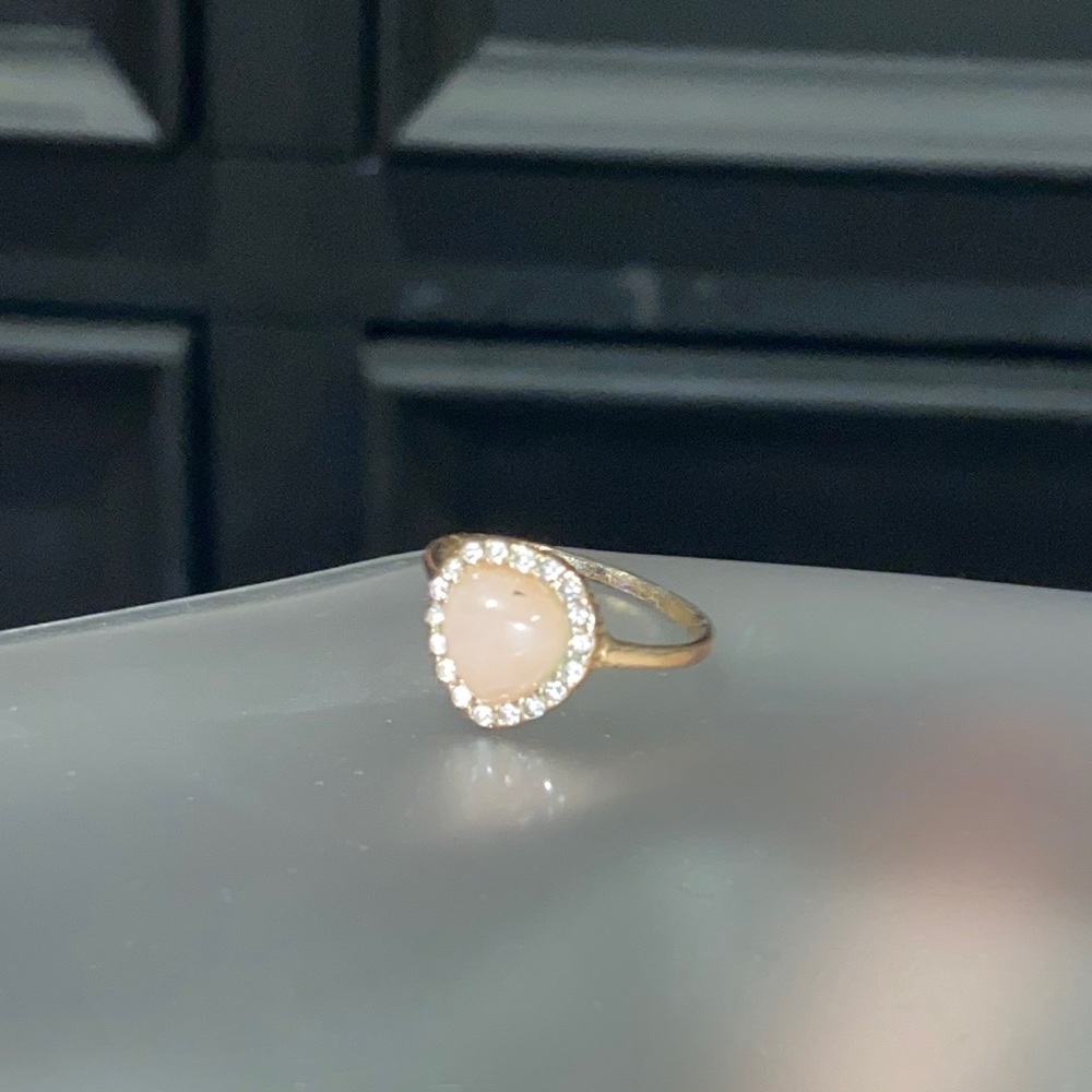 Gold ring with pink stone and surrounded by white crystals